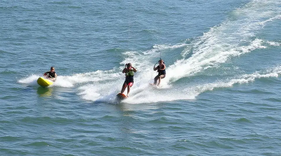 Two water skiers behind a boat on open sea